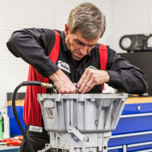 A Ralph's technician pulls at certain parts on a mechanism for a vehicle.