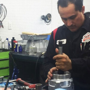A Ralph's technician examines the workings of a car part.