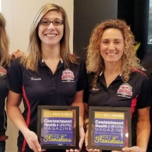 The Ralph's Transmission team holding up their rewards in front of a window.
