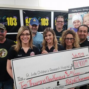 A group of people hold a ten thousand nine hundred dollar check.