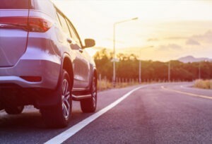 An image of a silver SUV on a sunny road.