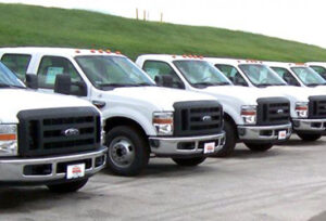 An image of a fleet of white trucks.