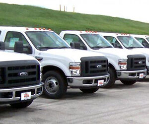 An image of a fleet of white trucks.