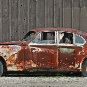 An image of an old 1940s car covered in rust.