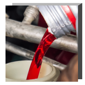 Red liquid is poured into a white tube.