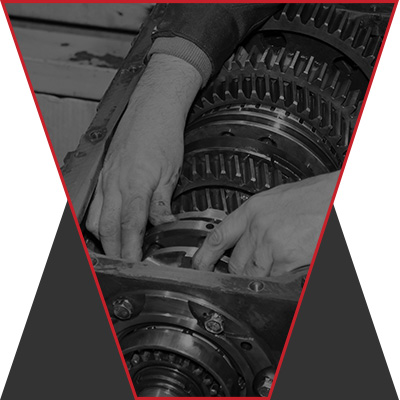 A black and white, designed image of a mechanic fiddling with car parts.