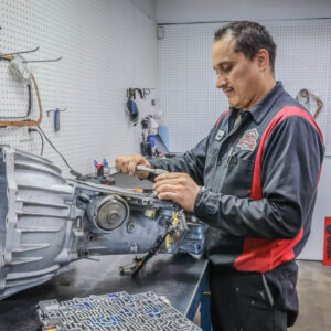 A Ralph's technician works on a part that is separated from the vehicle.