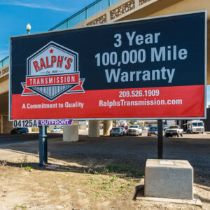 A Ralph's Transmission billboard that reads "3 year 100,000 mile warranty."