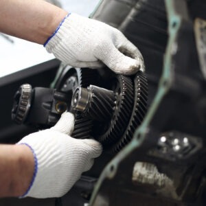 A man with soft, white gloves adjusts components in a vehicle.