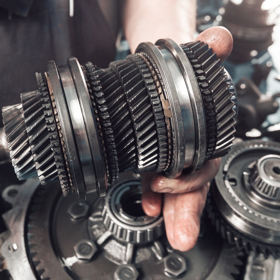 A mechanic holding car transmission parts
