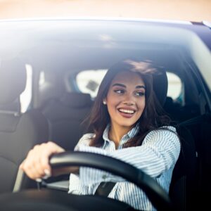 A happy woman driving her car
