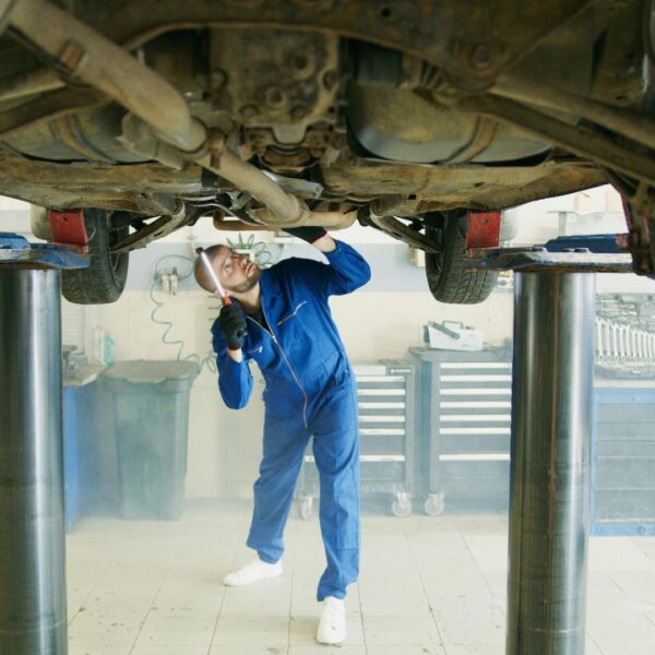 a mechanic looking under a vehicle
